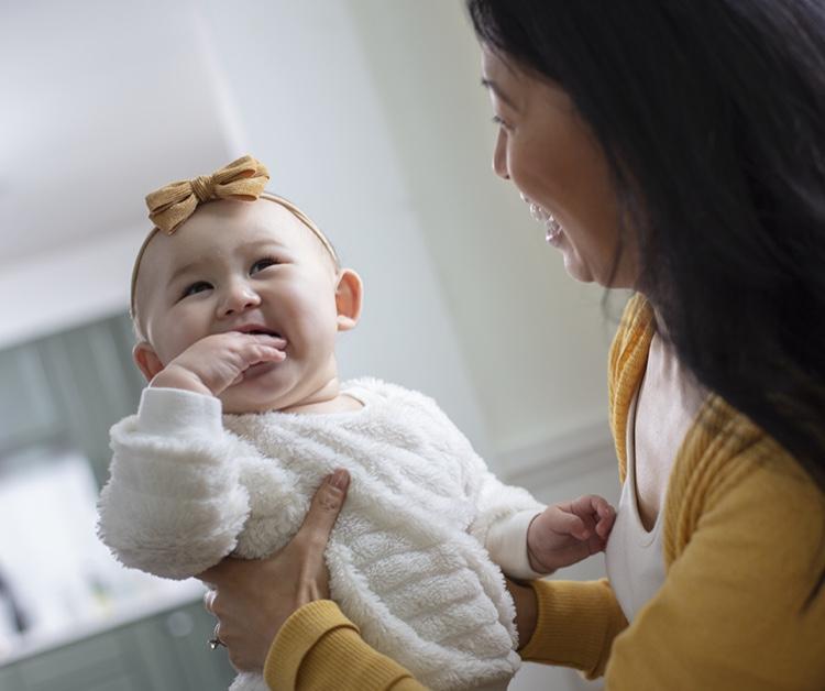 Mom holding smiling baby