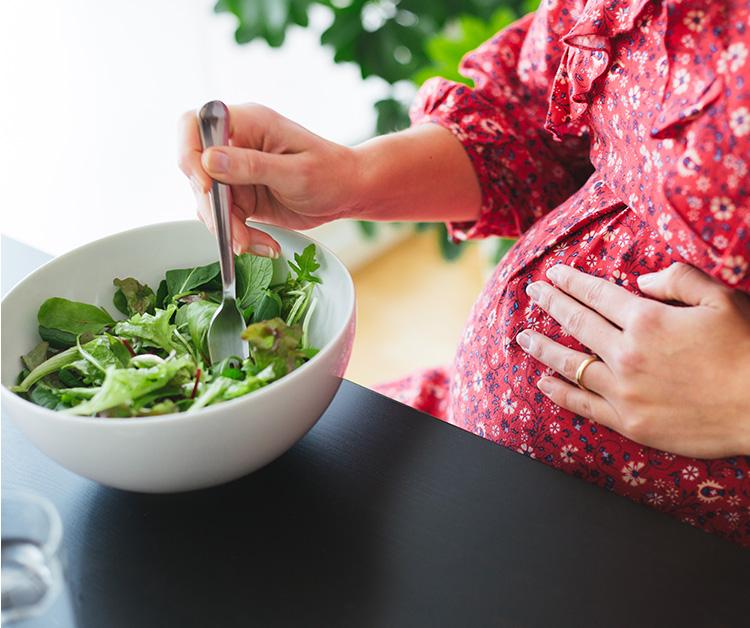 Pregnant woman eating a salad