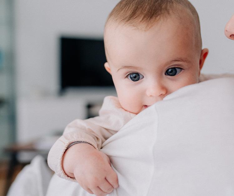 Baby peeking over mom's shoulder